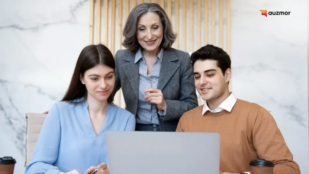 HR leader supporting two employees working together on a laptop