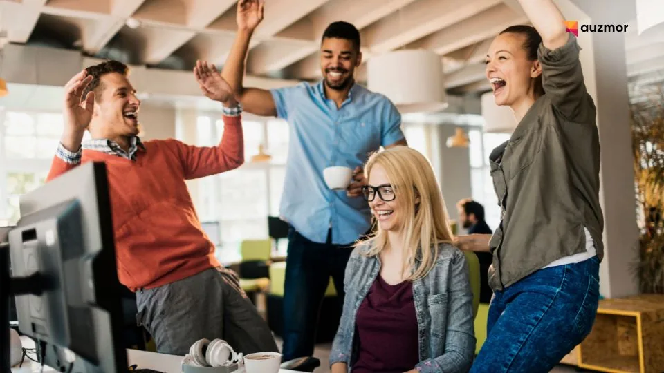 Excited coworkers celebrating and cheering together in the office